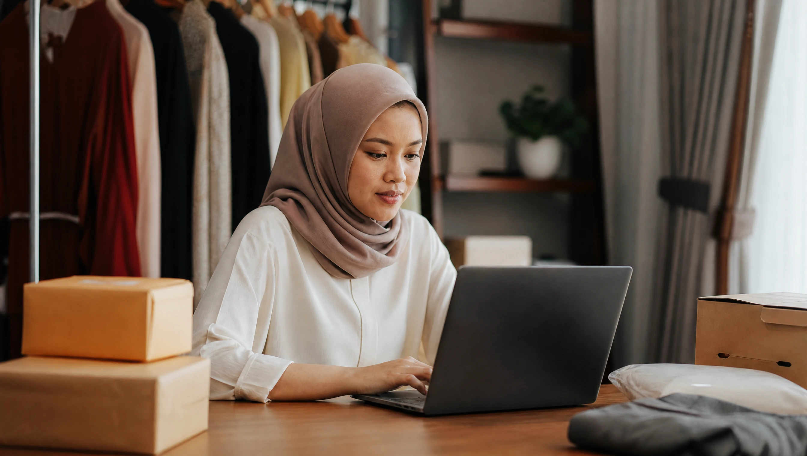 Pemilik butik online Melayu di Johor Bahru menyemak carian Google di komputer riba di rumah