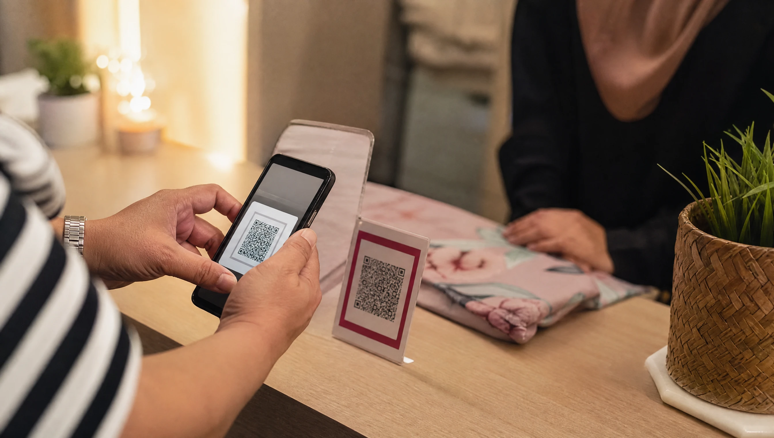 Pelanggan Malaysia mengimbas kod DuitNow QR menggunakan telefon untuk membayar pembelian dalam talian
