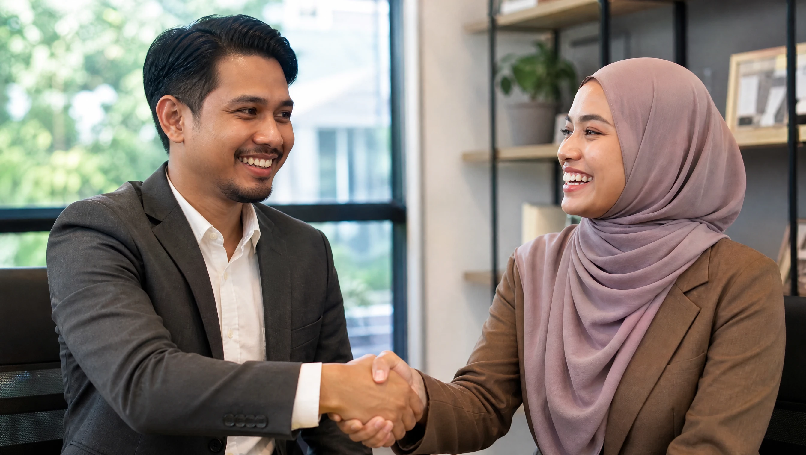 Peniaga Malaysia berjabat tangan meraikan pendaftaran domain baru untuk bisnes di pejabat