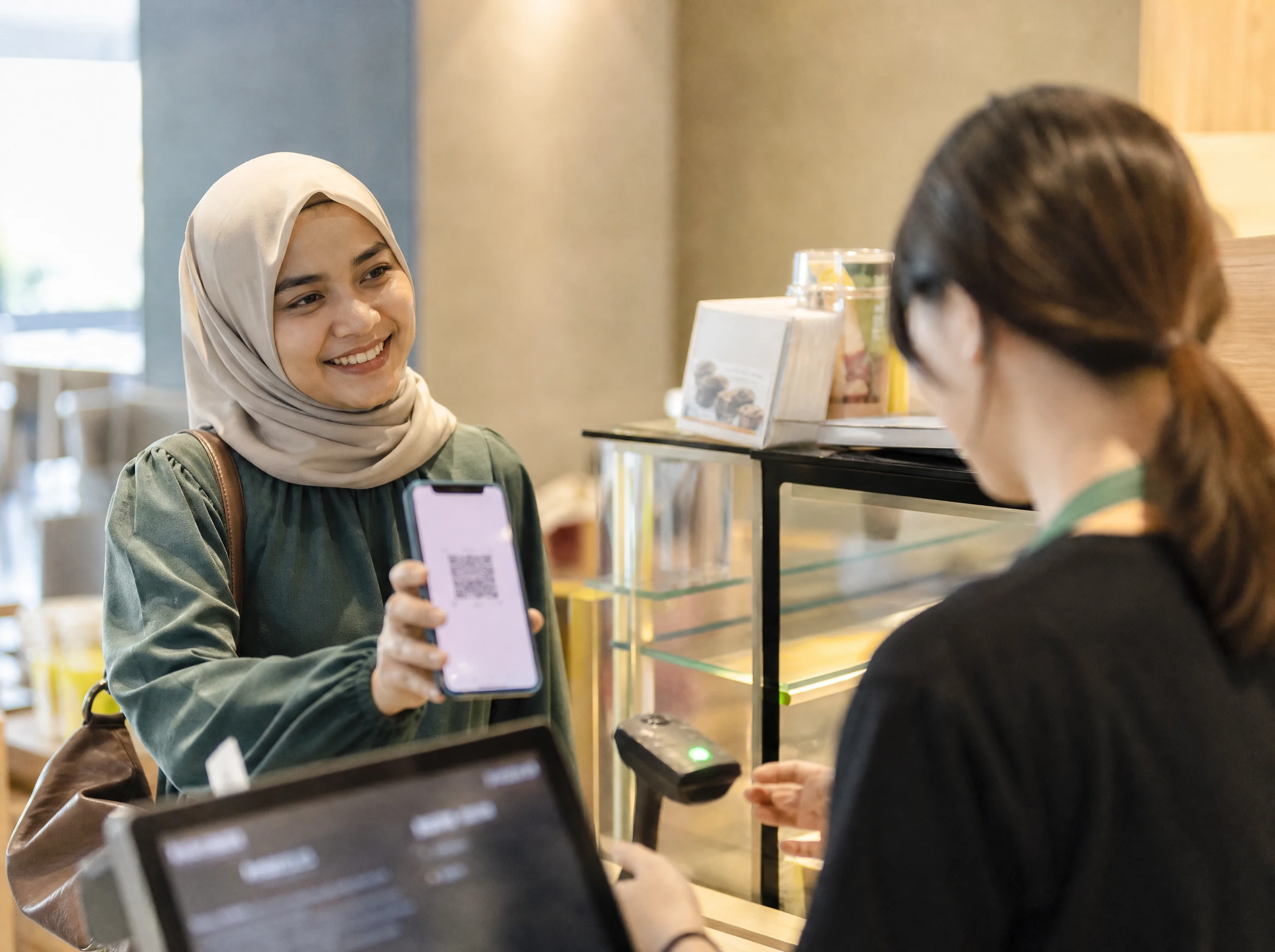 Customer showing a loyalty app QR code at a cafe counter
