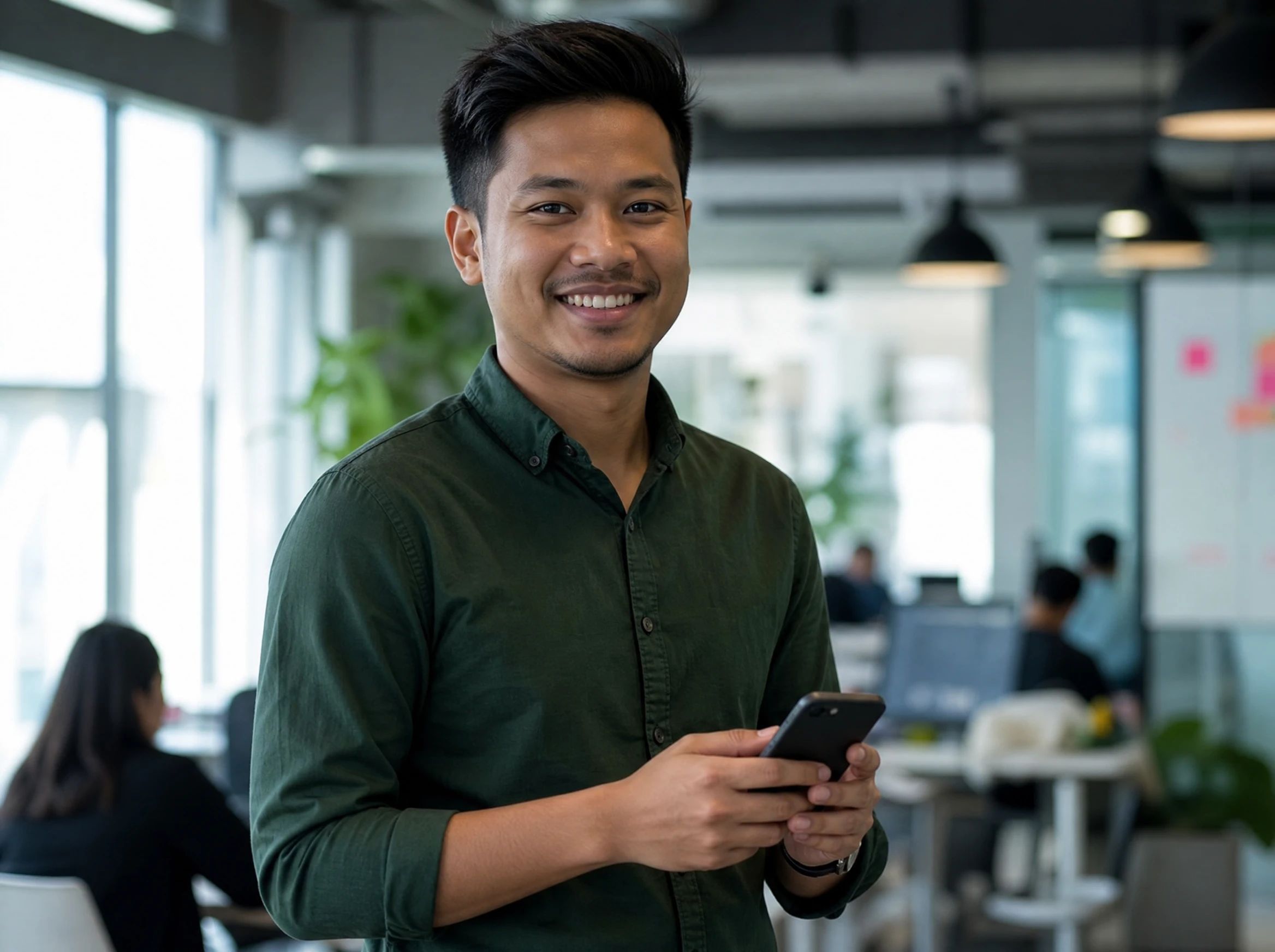 Confident Malaysian app product lead holding a smartphone