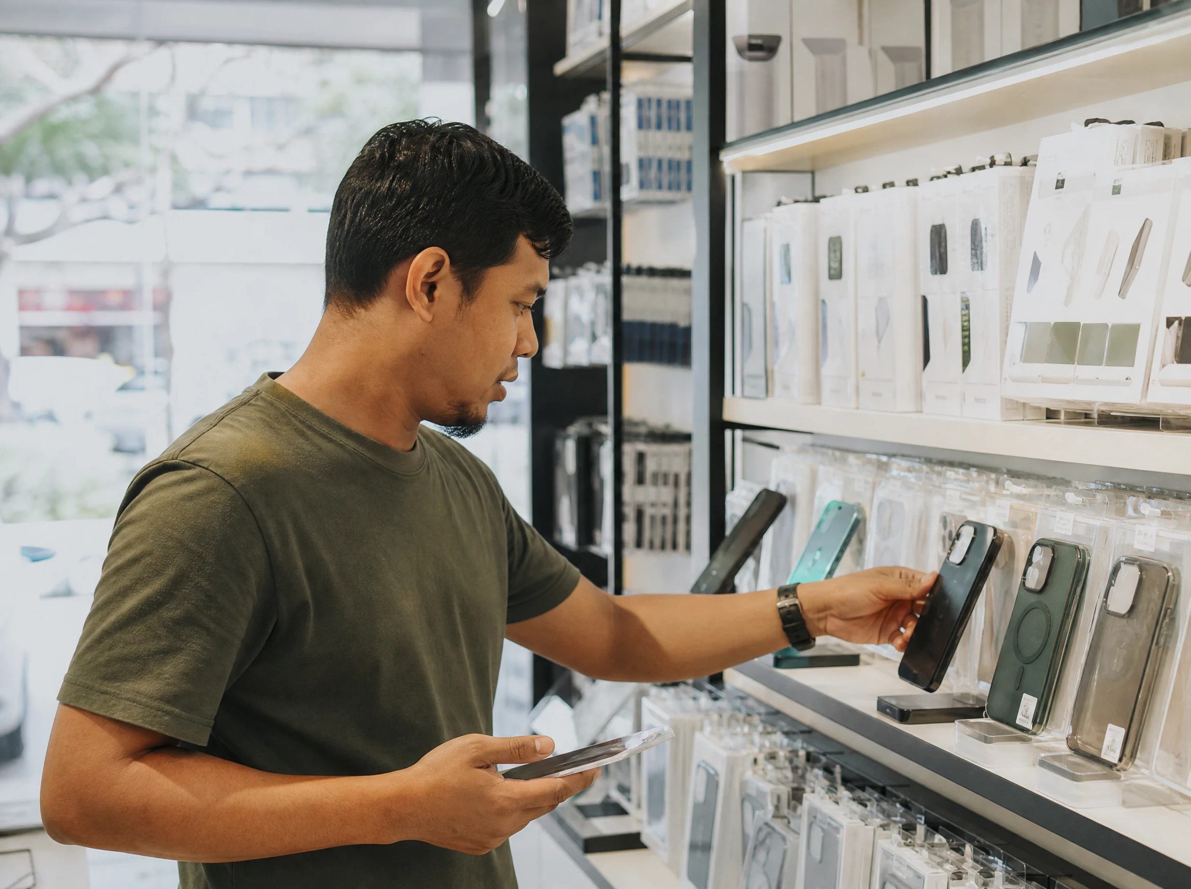 Malaysian man checking gadgets in an electronics shop