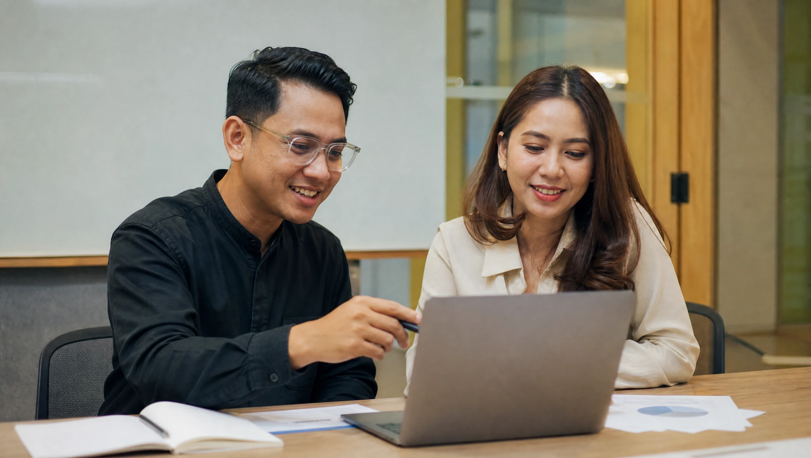 Malaysian support specialist reviewing a monthly health report with a client