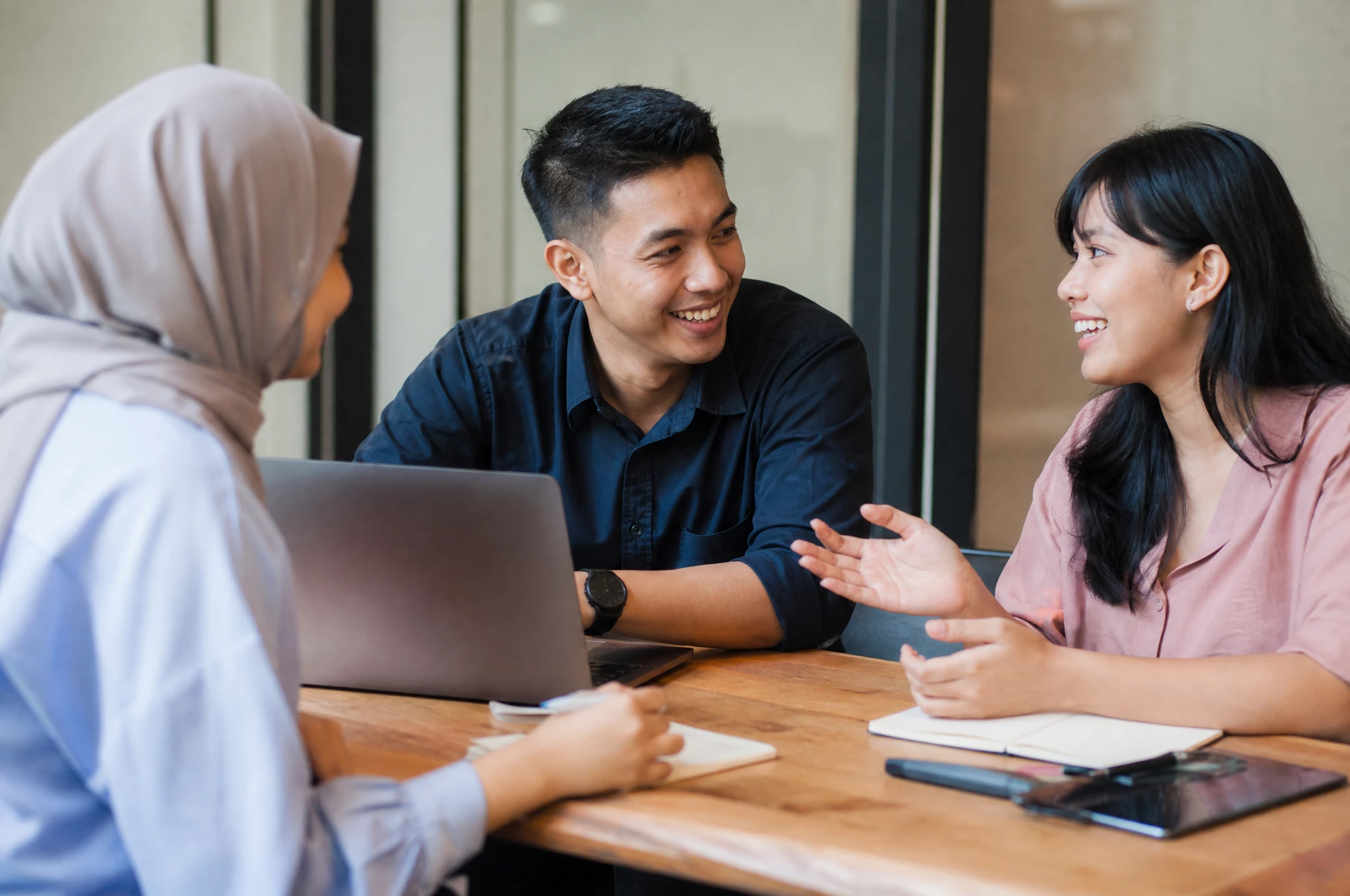 Friendly Malaysian marketing team consulting with a business client