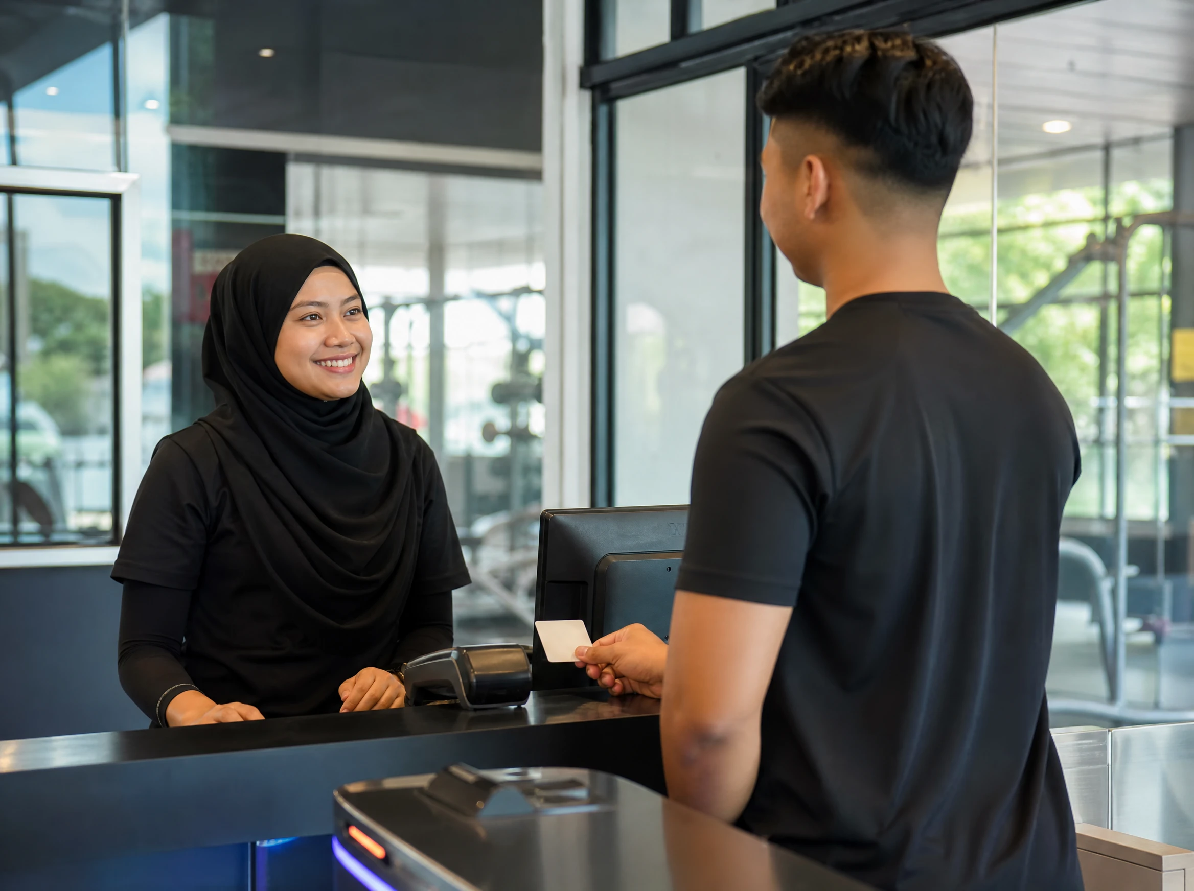 Malaysian gym staff checking a member in on a membership system