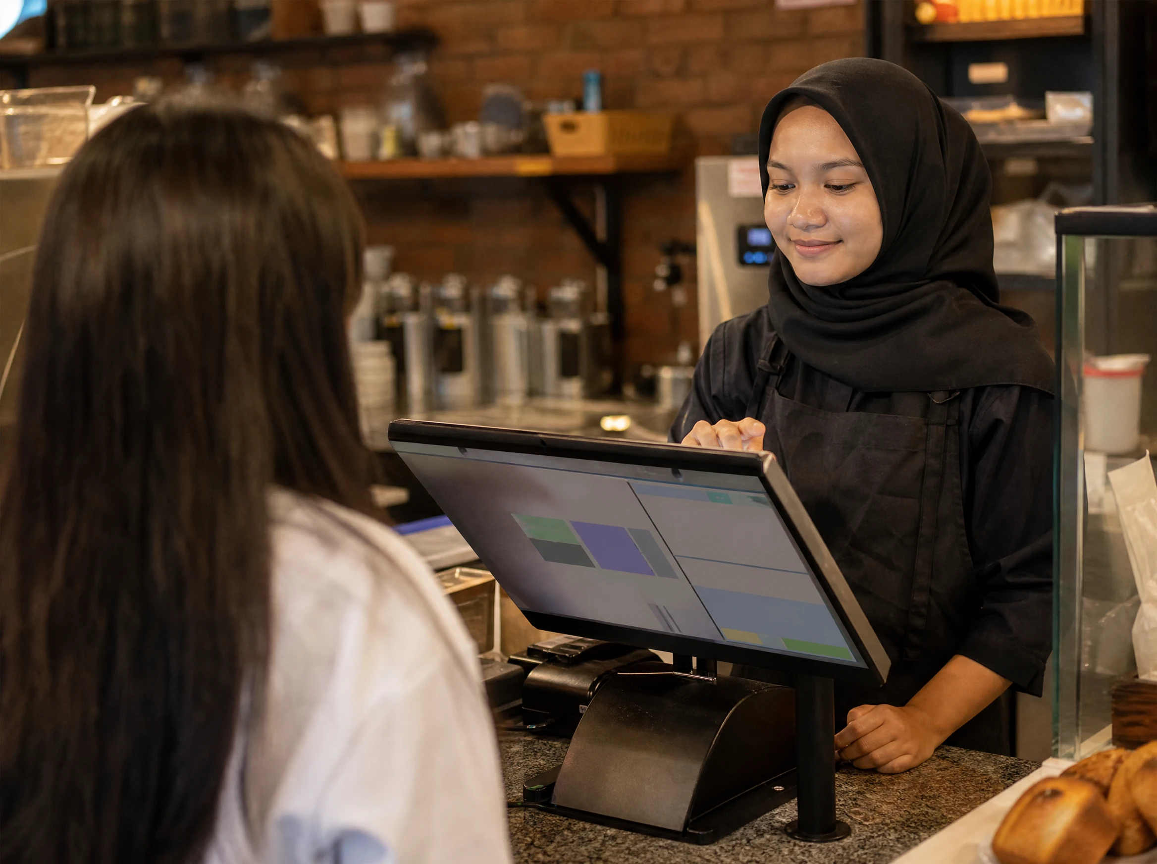Malaysian cafe cashier using a point-of-sale order system