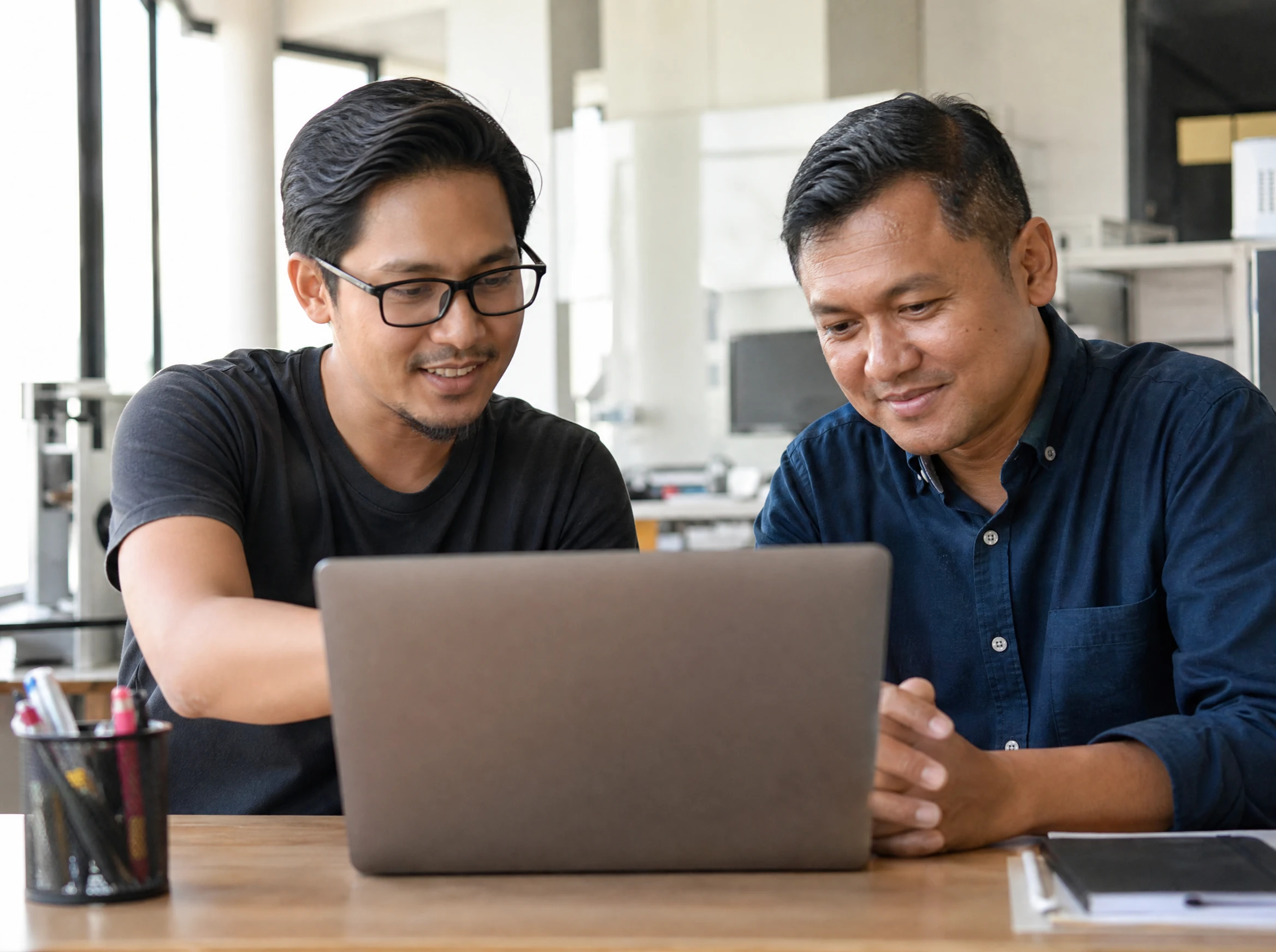Malaysian designer showing a client how to manage their new website