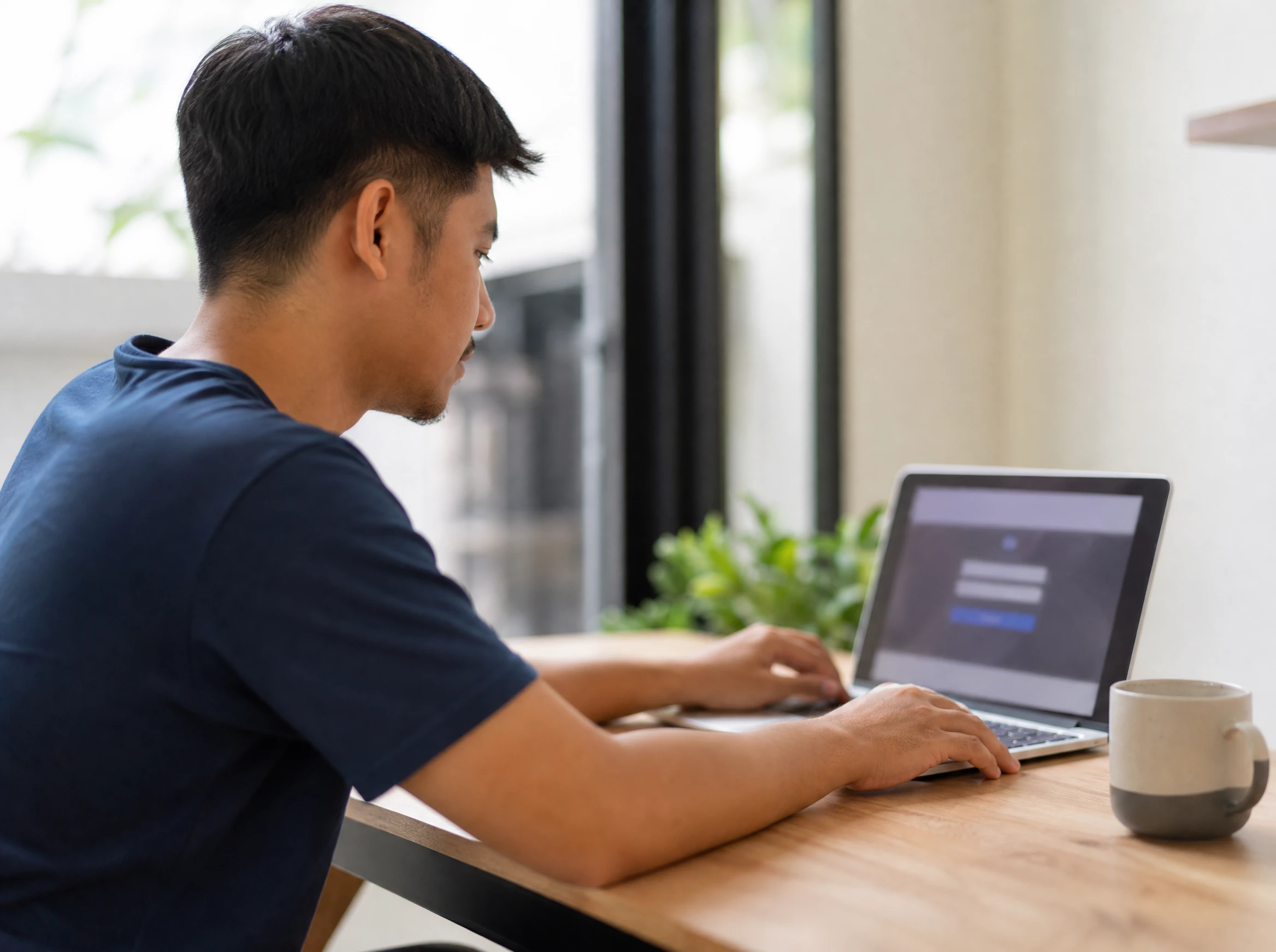 Person logging into an online member portal on a laptop