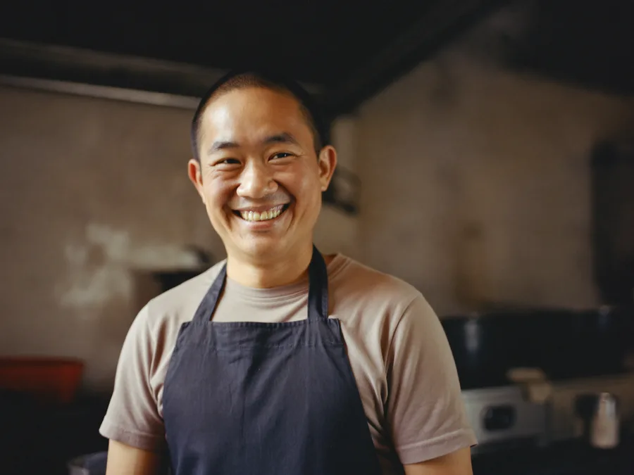 Malaysian restaurant owner managing orders on a desktop PC